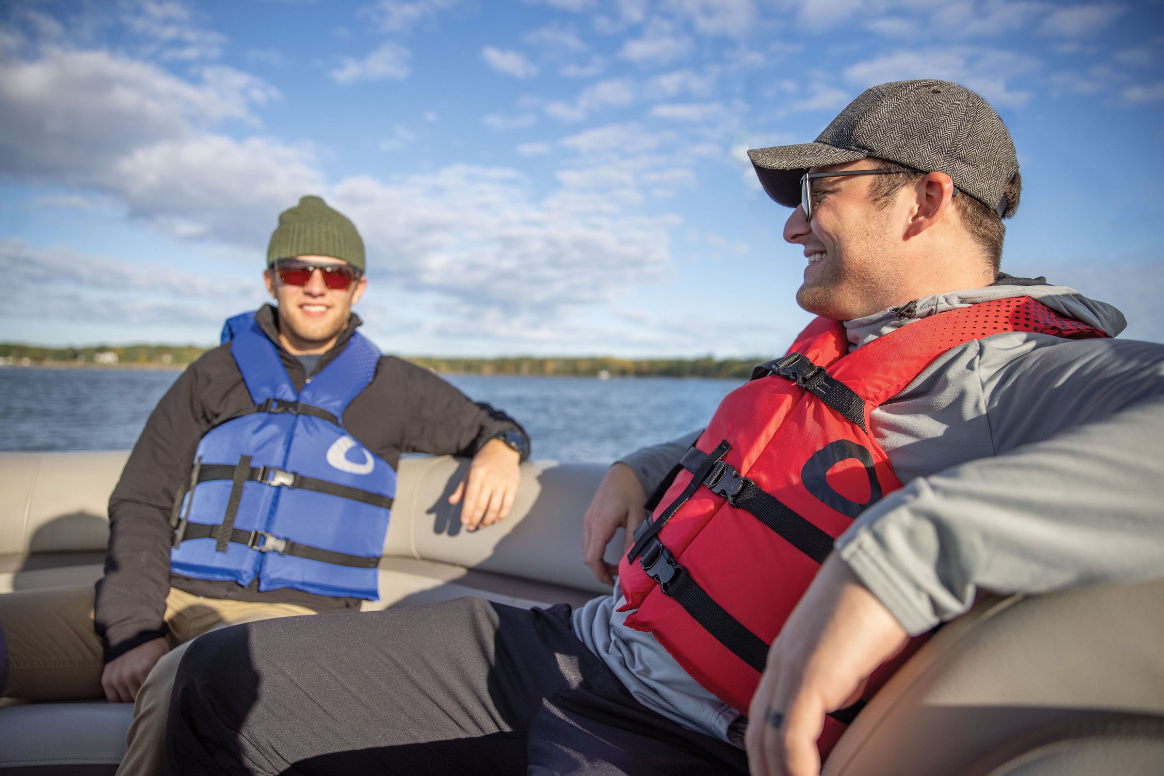 Two men on a boat wearing a red and a blue Onyx Adult Life Vests.